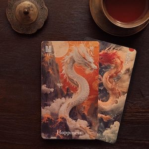May include: Two rectangular oracle cards featuring detailed illustrations of dragons amidst clouds and mountains. The left card displays a white dragon, the number 11, and the word Happiness. The right card shows a red and gold dragon with Chinese text.