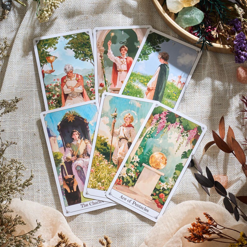 May include: A collection of tarot cards featuring detailed illustrations with a vintage aesthetic. The cards depict figures in classical attire and scenes with floral and architectural elements. The text "The Chariot" and "Ace of Pentacles" are visible.