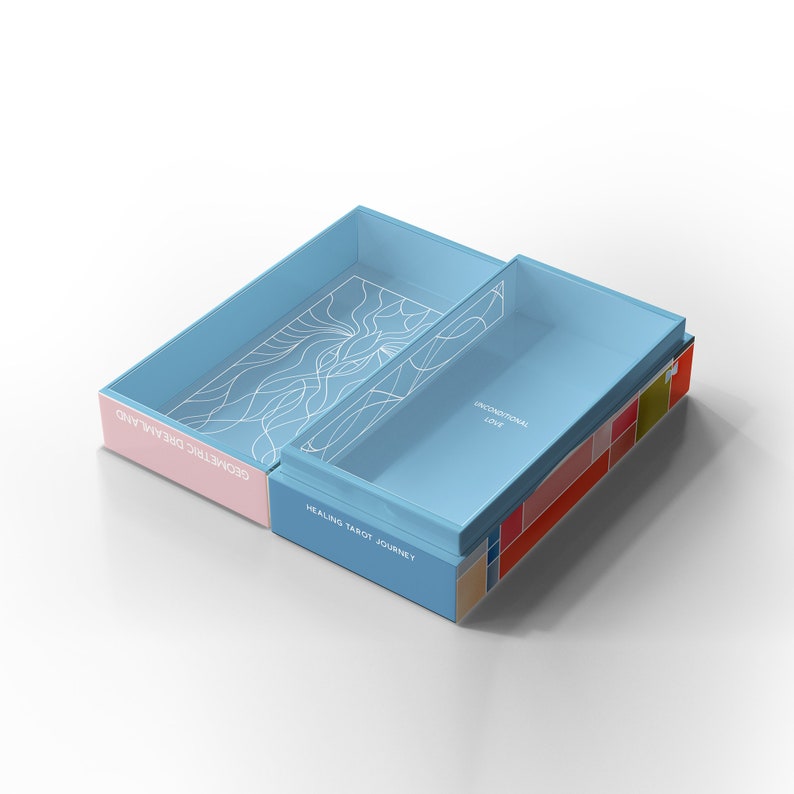 K&ouml;nnte beinhalten: Eine blaue Box mit einem rosafarbenen Deckel, ge&ouml;ffnet, um ein Tarot-Kartenspiel zu enth&uuml;llen. Die Box tr&auml;gt den Text "HEALING TAROT JOURNEY" auf der Vorderseite und "GEOMETRIC DREAMLAND" an der Seite. Die Karten sind in der Box sichtbar, mit einem wei&szlig;en geometrischen Design auf der obersten Karte.