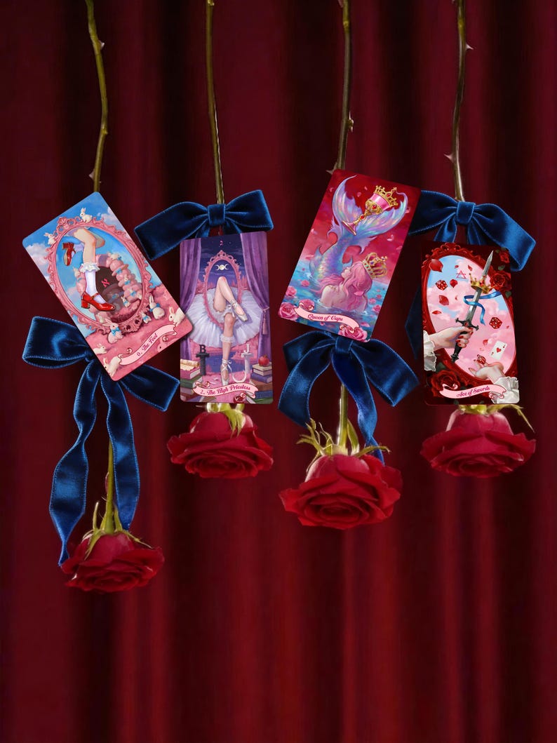 May include: Four tarot cards hanging from long stems, each adorned with a dark blue velvet bow and a deep red rose at the bottom. The cards feature illustrations including a leg in a red shoe, a ballerina, a mermaid, and a hand holding a sword.