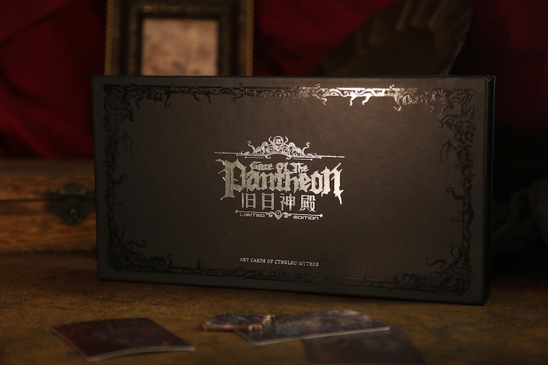 May include: A rectangular black box featuring silver foil text that reads Gaze of the Pantheon, Chinese characters, and Limited Edition. The box has an ornate, dark, vine-like border design and the text Art Cards of Cthulhu Mythos at the bottom.