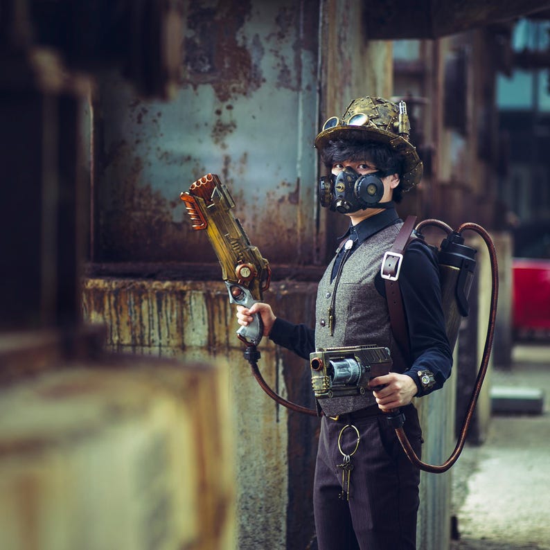 May include: A person wearing a steampunk-style outfit with a gas mask, goggles, and a vest. They are holding a futuristic-looking weapon and have a backpack with tubes and a tank.