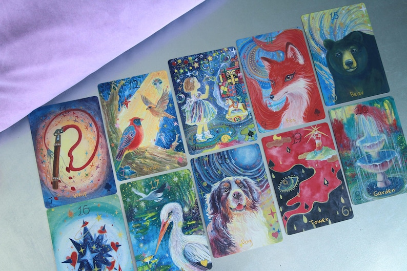 May include: A collection of rectangular oracle cards featuring colourful, detailed illustrations of animals, nature, and symbolic objects. Each card displays a unique painting, including a bear, fox, dog, stork, bird, fountain, and tower, with numbers and text labels.