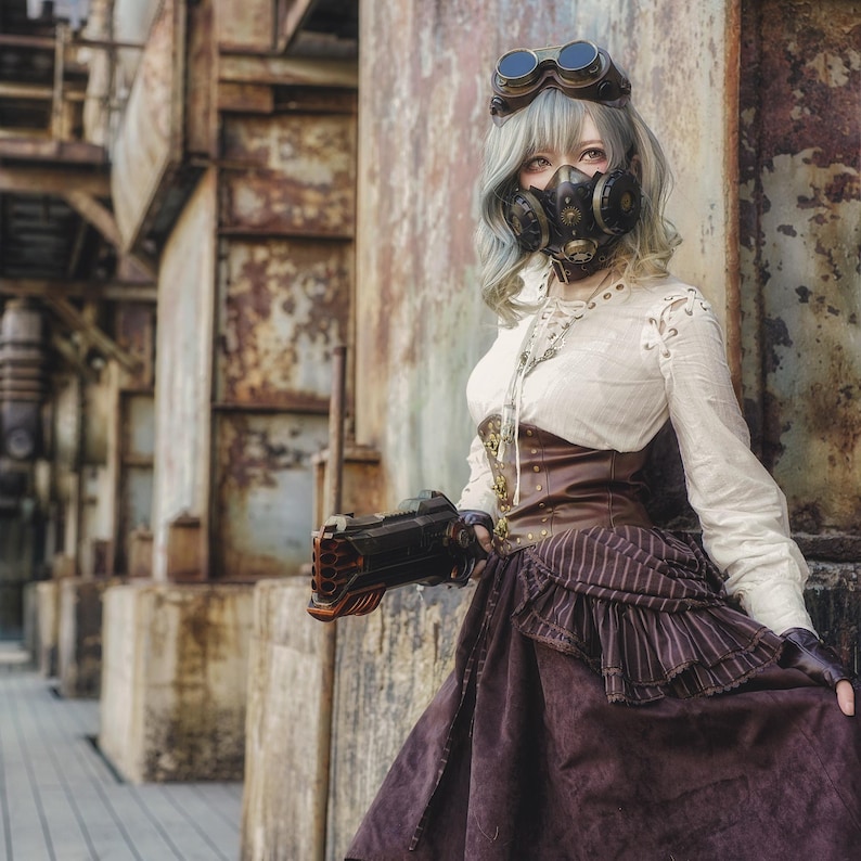 May include: A woman in a steampunk-inspired outfit with a gas mask, goggles, and a brown leather corset. She is holding a toy gun and is standing in front of a rusty metal background.