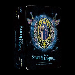 May include: A tarot card deck titled "Starry Enigma" with a black background. The card features a stained-glass style illustration with a central figure, surrounded by ornate floral and celestial designs. The deck's spine also displays the title.