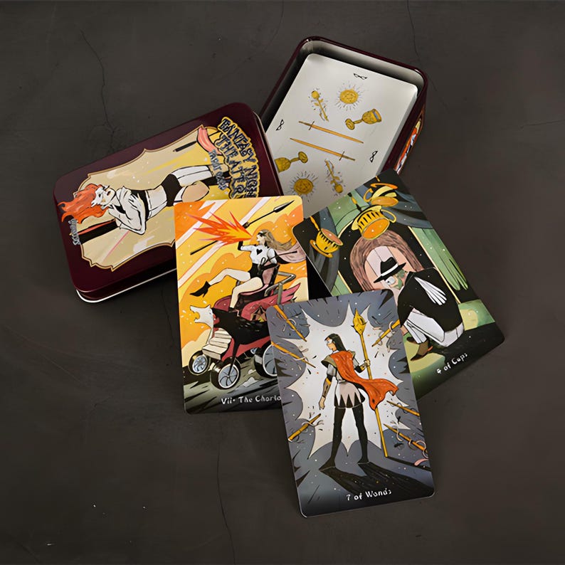 May include: A tarot card deck with a burgundy metal tin. The tin features a woman in a black and white outfit. Several tarot cards are visible, each with unique illustrations and titles like "VII - The Chariot" and "7 of Wands".