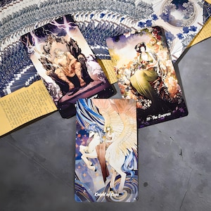 Puede incluir: Un conjunto de cartas de tarot con ilustraciones detalladas. Una carta muestra una figura en un trono con rel&aacute;mpagos, otra una mujer en un entorno floral, y una tercera un caballo alado con un jinete. El texto "Knight of Cups" es visible.