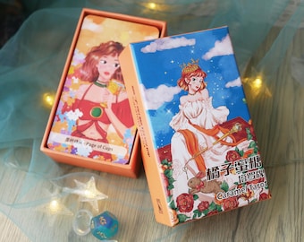 Puede incluir: Un juego de cartas de tarot Caramel en una caja naranja. La caja presenta un fondo de cielo azul con una mujer con un vestido blanco y una corona. Las cartas muestran ilustraciones de mujeres. El texto "Page of Cups" es visible.