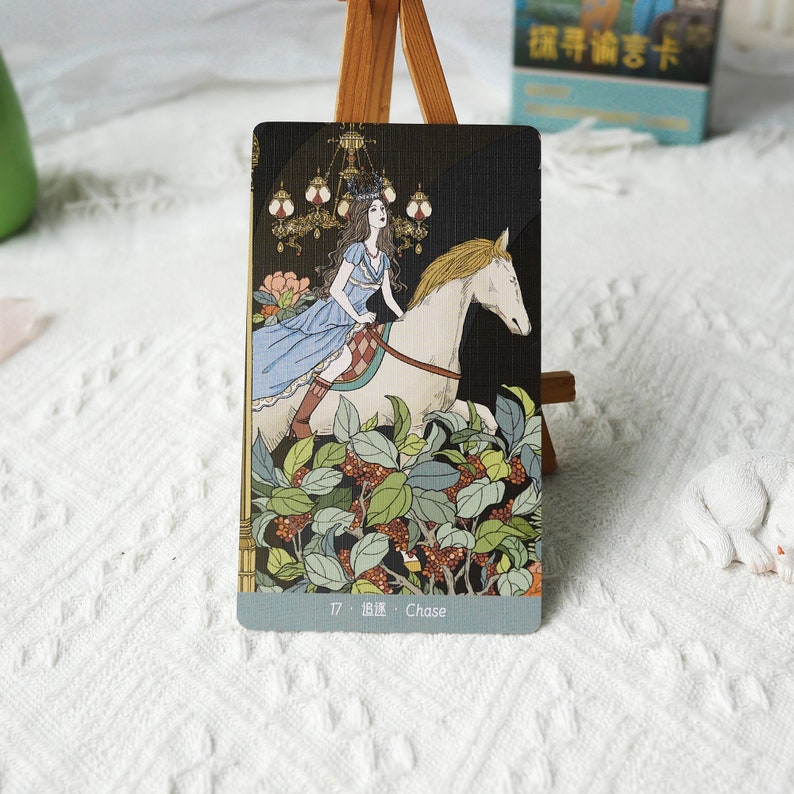 May include: A tarot card with a woman riding a white horse through a forest. The card is numbered 17 and titled "Chase".