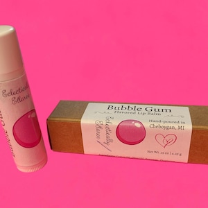 May include: A pink and white lip balm tube with a bubble gum design. The tube is labeled "Eclectically Ellaree" and "Bubble Gum". The lip balm is hand-poured in Cheboygan, MI. The lip balm is 0.15 oz or 4.25 g.