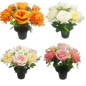 May include: Four artificial flower arrangements in black pots. The arrangements feature a single rose with smaller flowers surrounding it. The roses are orange, white, pink, and cream.