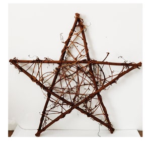 May include: A large, rustic, brown, five-pointed star made of woven twigs and branches.