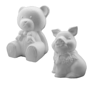 May include: Two white ceramic figurines, a bear and a pig, ready to be painted. Both figurines are sitting with their legs crossed and have a bow tied around their necks.