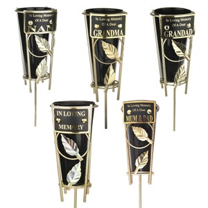 May include: Five black metal flower vases with gold accents and a gold stand. Each vase has a gold plaque with the text "In Loving Memory Of A Dear" and a personalized message: "NAN", "GRANDMA", "IN LOVING MEMORY", "MUM & DAD", and "GRANDAD".