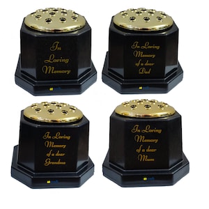 May include: Four black octagonal flower vases with gold tops. Each vase has a different inscription: "In Loving Memory of a dear Dad", "In Loving Memory of a dear Grandma", "In Loving Memory of a dear Mum", and "In Loving Memory".