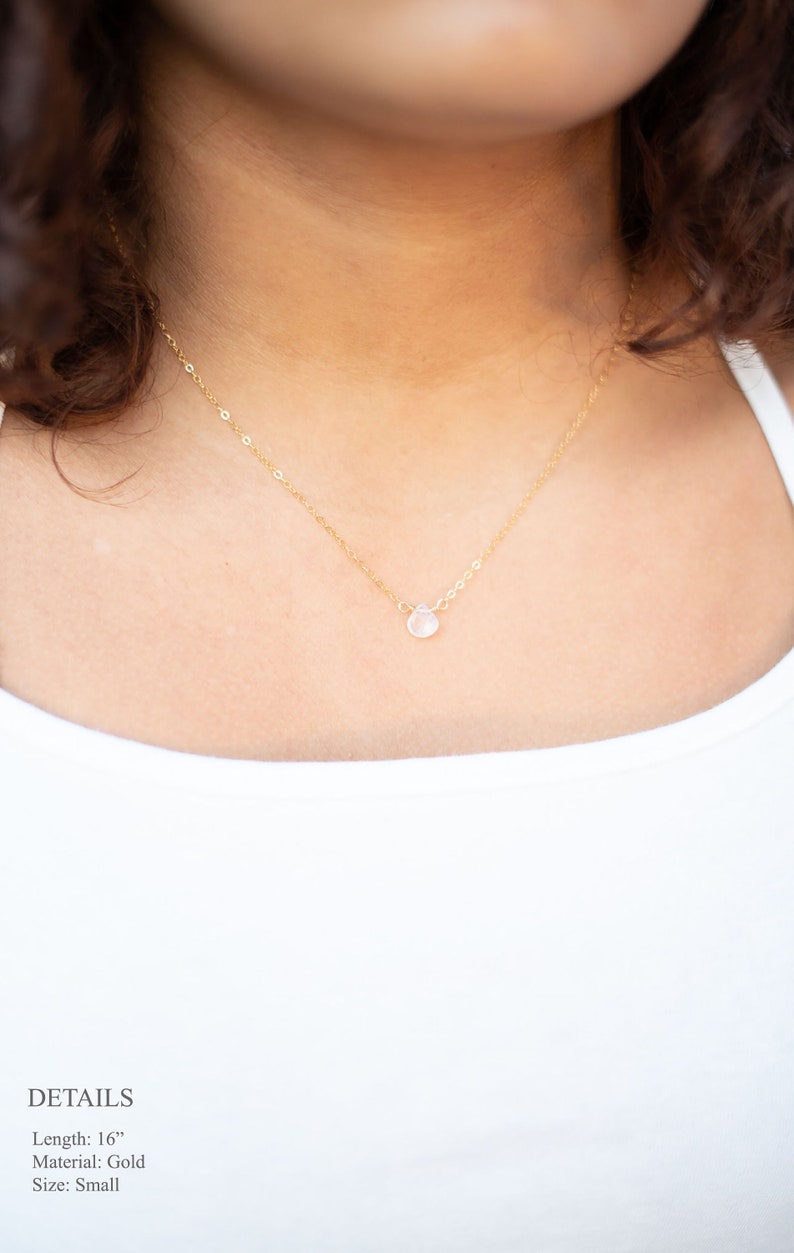 Puede incluir: Un delicado collar de cadena de oro con un peque&ntilde;o colgante de piedra preciosa transparente. El collar mide 40,6 cm de largo y est&aacute; hecho de oro. El colgante es peque&ntilde;o y redondo, y est&aacute; engastado en un engaste de oro. El collar es una pieza de joyer&iacute;a simple y elegante que ser&iacute;a un gran regalo para cualquier ocasi&oacute;n.