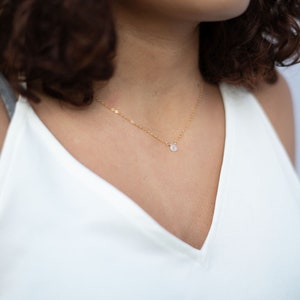 Puede incluir: Un delicado collar de cadena de oro con un peque&ntilde;o colgante redondo de piedra blanca. El collar mide 40,6 cm de largo. DETALLES: Longitud: 16" Material: Oro Tama&ntilde;o: Tiny