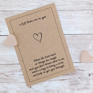 May include: A brown card with a heart drawn on it and the text "a HUG from me to you". The card has a poem about hugs and how they can help when life is tough.