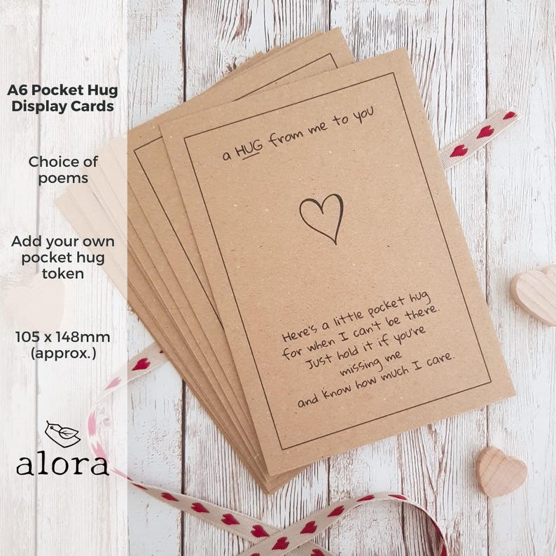 May include: A set of brown kraft paper cards with a handwritten message that reads "a HUG from me to you". The cards are 105 x 148 mm and are designed to be used as pocket hug tokens.