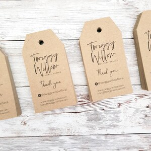 Puede incluir: Una pila de etiquetas de regalo de papel marr&oacute;n con el texto "Twiggy Willow Floral Design" y "Gracias" impreso en ellas. Las etiquetas tambi&eacute;n incluyen el nombre de usuario de las redes sociales "@twiggywillowfloral" y la direcci&oacute;n del sitio web "www.twiggy-willow.com".
