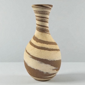 May include: A ceramic vase with a beige base and brown, swirling stripes. The vase has a rounded body and a long, slender neck. The decorative vase is a unique home decor item.