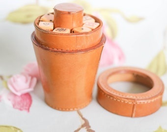Fine old leather dice shaker with poker dice and gaming dice