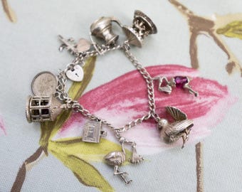 Edwardian silver charm bracelet: 9 charms, 52g weight