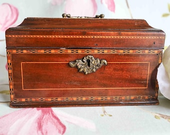 George III mahogany tea caddy: chevron strung, molded cover, mounted foliate cast brass handle and original key