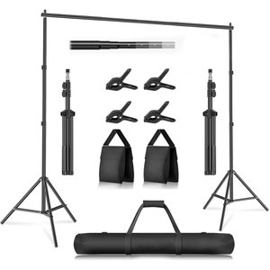 May include: A black photography backdrop stand with two adjustable tripods, a telescopic crossbar, four black clamps, two black carrying bags, and a black carrying case.