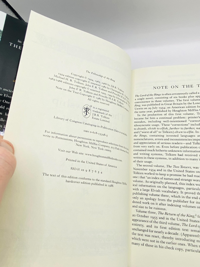 May include: Open book with text from "The Fellowship of the Ring" by J.R.R. Tolkien. The page shows copyright information and a note on the text. The book is printed in the United States of America.