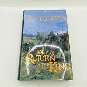 May include: A hardcover book titled "The Return of the King" by J.R.R. Tolkien. The cover features a painting of riders on horseback, with a mountain range in the background. The title is in gold lettering.