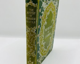 May include: A green and gold book with a floral design on the cover. The title of the book is "The Mystery of Cloomber Doyle".