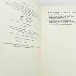 May include: Open book pages with text from "The Lord of the Rings" and copyright information. The title "The Return of the King" is visible. The text includes the famous poem about the rings. The book is a hardcover edition.
