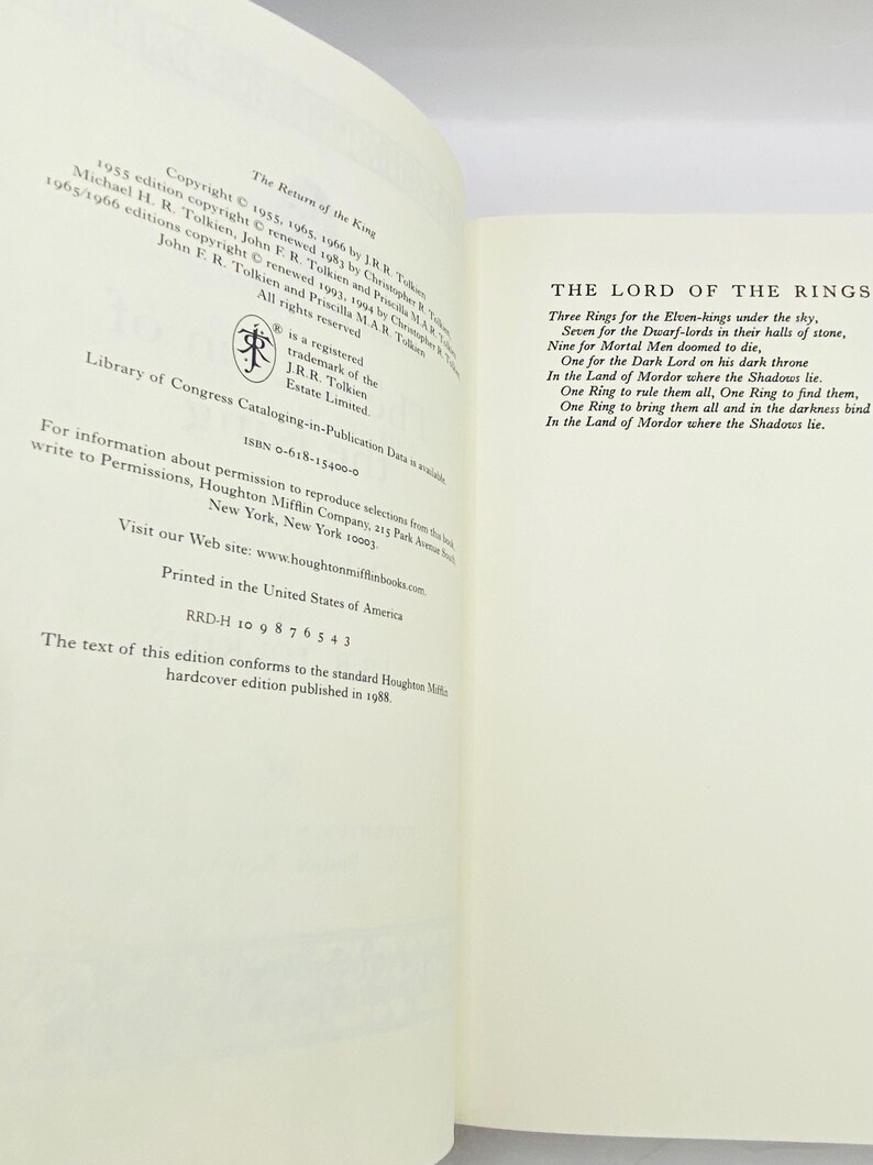 May include: Open book pages with text from "The Lord of the Rings" and copyright information. The title "The Return of the King" is visible. The text includes the famous poem about the rings. The book is a hardcover edition.