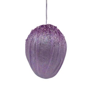 May include: A purple, glittery Easter egg ornament with a textured surface.