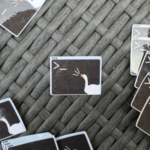 May include: A white goose honking in a computer window with a black background and the text ">_" in the top left corner.