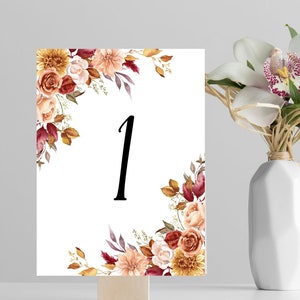 May include: A white card with a floral design in shades of red, orange, and yellow. The number "1" is printed in black in the center of the card.