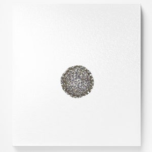 Op de afbeelding: Een close-up van een zilveren glitterbal ornament. De bal is rond en heeft een glinsterende afwerking.