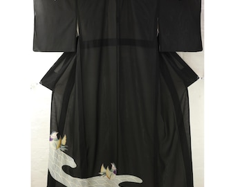May include: A black kimono featuring a sheer, lightweight fabric with long, wide sleeves. The lower section displays a white, wave-patterned graphic element with two colorful mandarin ducks, each with yellow, purple, and white plumage details.