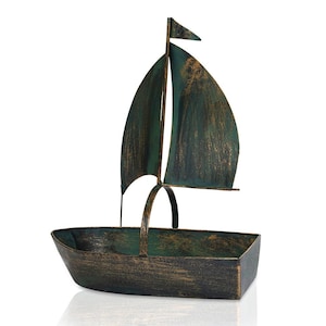 Puede incluir: Un macetero decorativo de metal con forma de velero con un acabado verde y dorado desgastado. El velero tiene una sola vela y una proa peque&ntilde;a y puntiaguda.