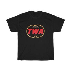 May include: Black t-shirt with a red "TWA" logo inside a gold circle with a globe design.
