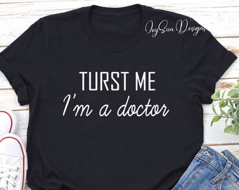 May include: Black t-shirt with white text that reads "Trust me, I'm a doctor".