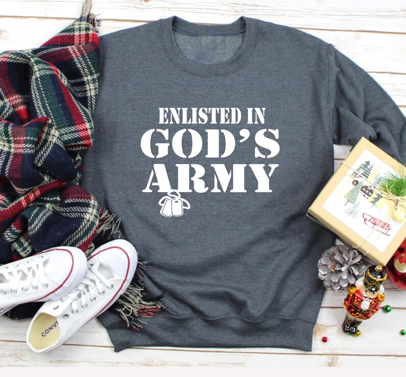 May include: A dark gray sweatshirt with the text "Enlisted in God's Army" in white lettering. The sweatshirt has a white outline of two dog tags.