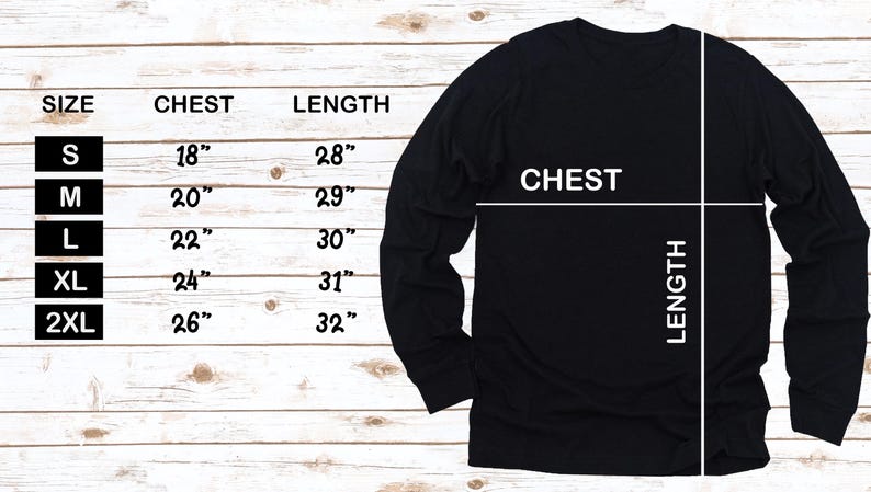 May include: Black long-sleeve shirt with size chart. The chart shows chest and length measurements in inches for sizes S to 2XL. The shirt has a crew neck and is displayed on a light wood grain background.