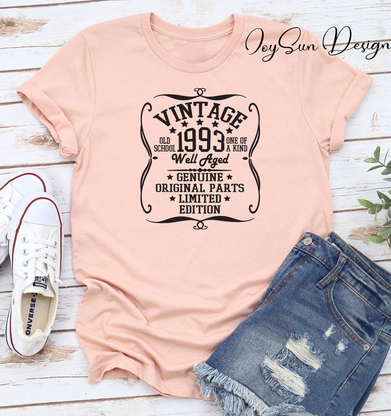 May include: A peach-colored t-shirt with a black vintage-style graphic that says "Vintage 1993 Old School Well Aged Genuine Original Parts Limited Edition".