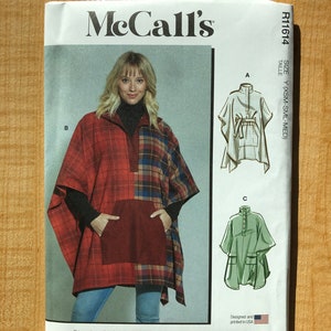 Könnte beinhalten: Ein Schnittmuster für einen Poncho mit mehreren Ansichtsoptionen. Das Muster enthält Anweisungen zum Nähen eines Ponchos aus rotem und schwarzem kariertem Stoff, eines weißen Ponchos mit schwarzer Schärpe und eines grünen Ponchos mit Knopfleiste. Das Muster wurde in den USA entworfen und gedruckt.