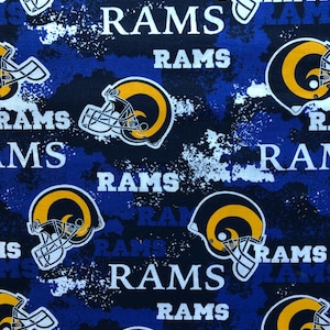 May include: Blue and black fabric with a repeated pattern of a football helmet with a yellow and white logo and the word "RAMS" in white letters.