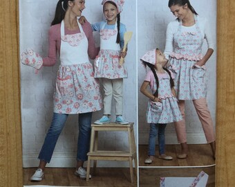 May include: Simplicity sewing pattern R11462 for aprons, oven mitts, and a chef's hat. The pattern features a floral print design. The text "Ruby Jean's Closet easy-to-sew" is visible. The pattern is designed and printed in the USA.