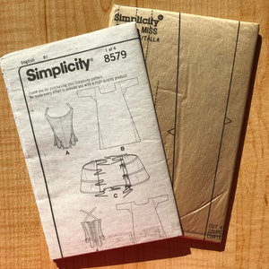 Pu&ograve; includere: Un cartamodello Simplicity per un vestito, con istruzioni e diagrammi. Il numero del cartamodello &egrave; 8579.
