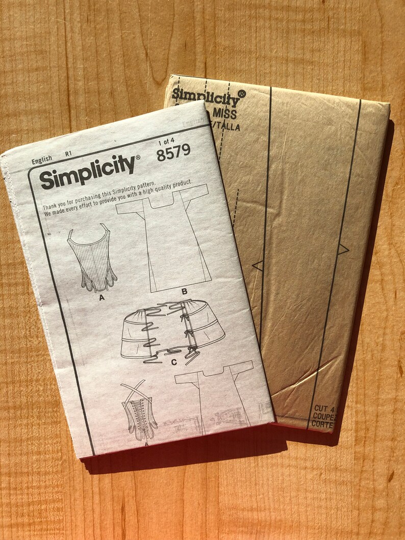 Pu&ograve; includere: Un cartamodello Simplicity per un vestito, con istruzioni e diagrammi. Il numero del cartamodello &egrave; 8579.
